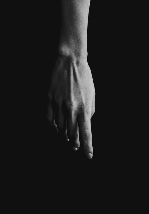 Free A black and white image showcasing a single hand against a dark background, emphasizing minimalism and fine art. Stock Photo