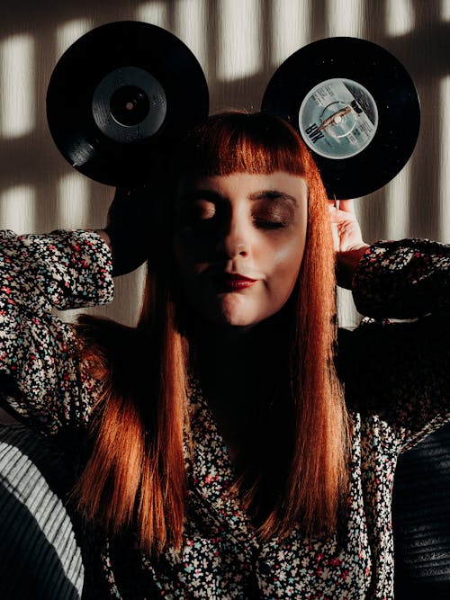 Red Hair Woman with Closed Eyes Holding Vinyl Records as Mouse Ears