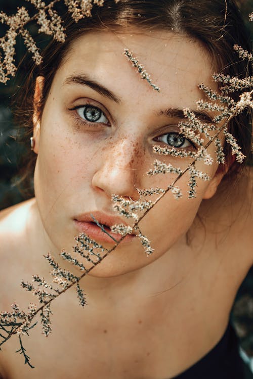 Girl Looking at Camera and with a Twig on Her Face