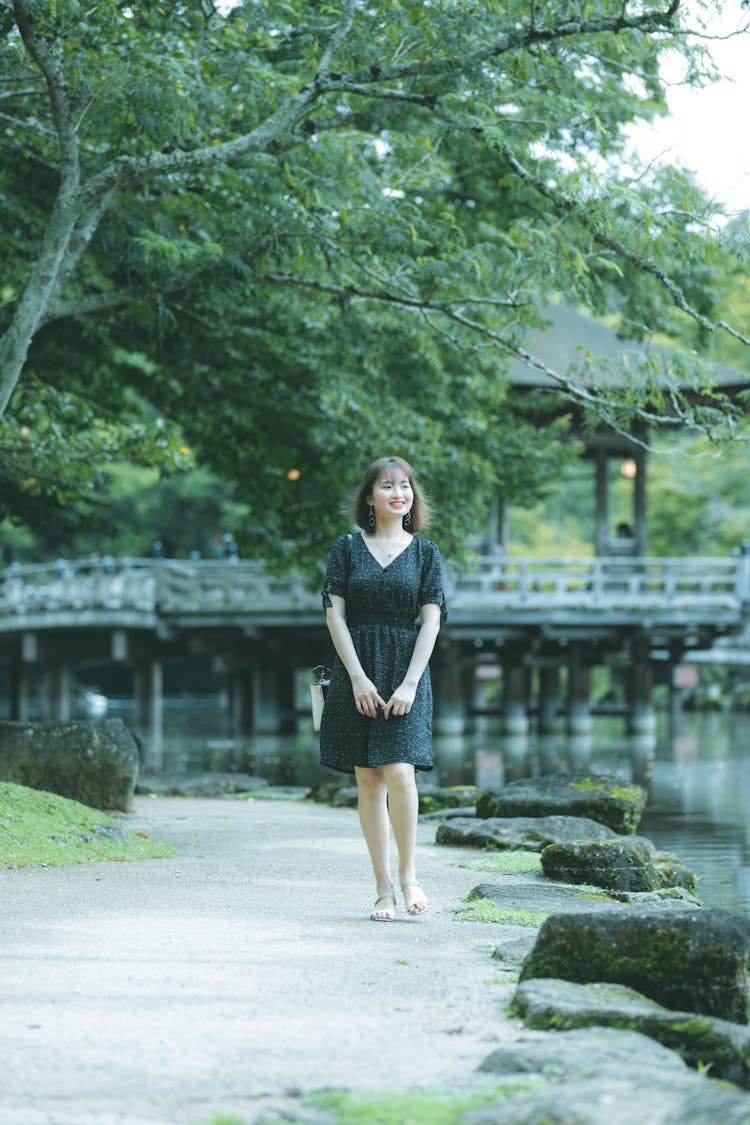 Woman In Black Dress Walking On Riverwalk