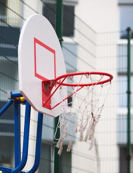 Close-up of an outdoor basketball hoop on a sunny urban sports court.