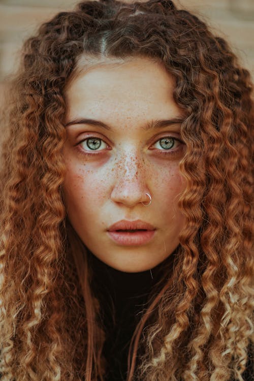 Girl with Curly, Ginger Hair Looking at Camera