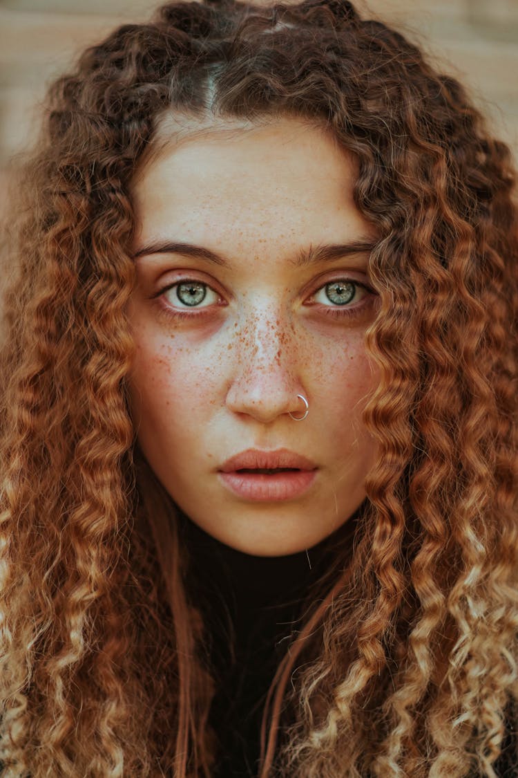 Girl With Curly, Ginger Hair Looking At Camera