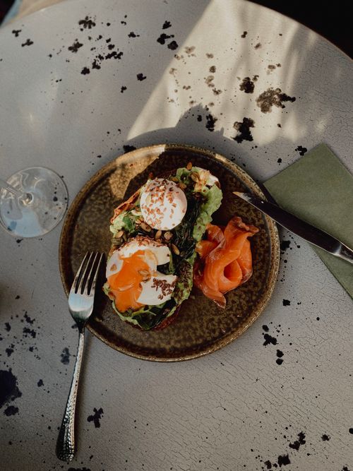 Free Gourmet dish with poached eggs on toast, topped with fresh greens and smoked salmon. Stock Photo