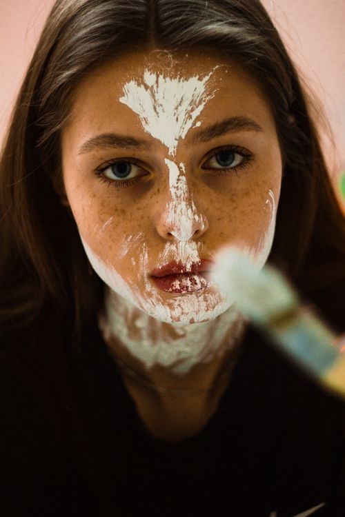 Free Close-up shot of a woman with artistic white face paint, showcasing beauty and creativity. Stock Photo