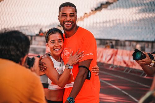 Free Runners share a joyful hug at marathon finish line, celebrating achievement. Stock Photo