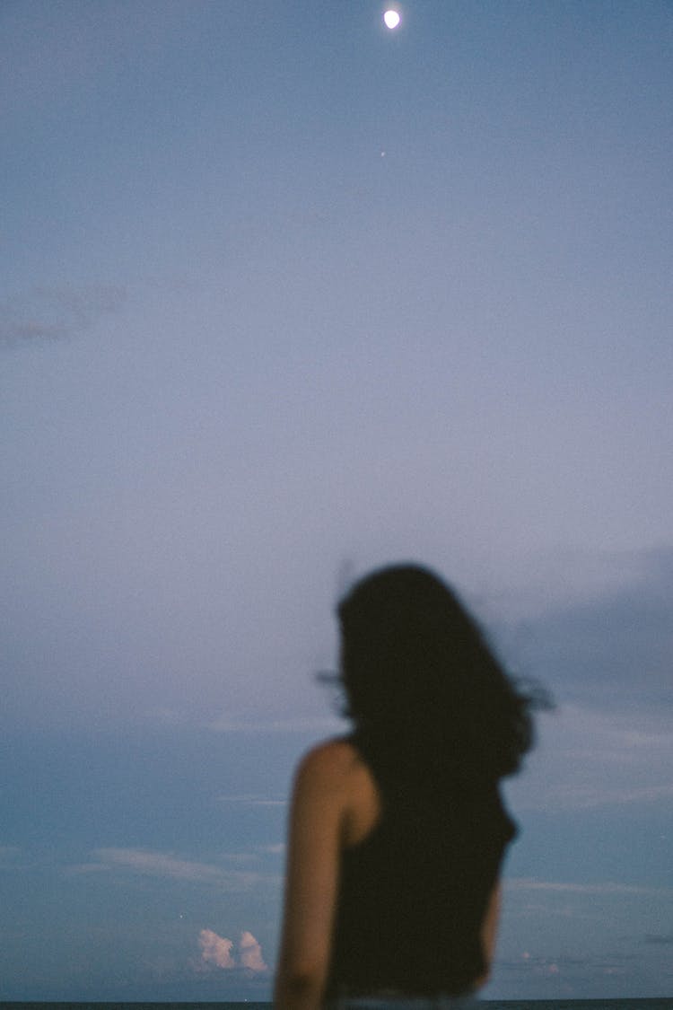 Woman With Long Black Hair Standing And Looking Into Distance