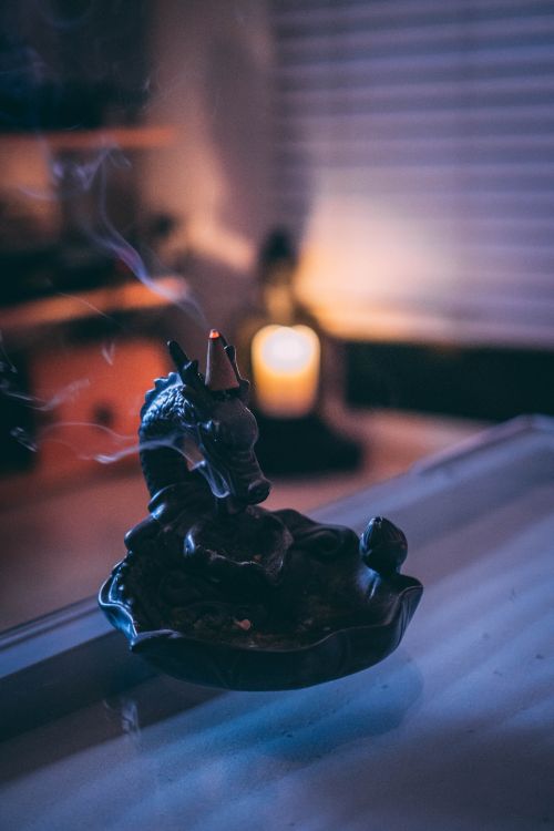 Free A serene mood captured with incense smoke swirling in a dimly lit room. Stock Photo