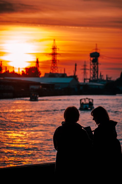 Silhouette of People Standing Near Body of Water