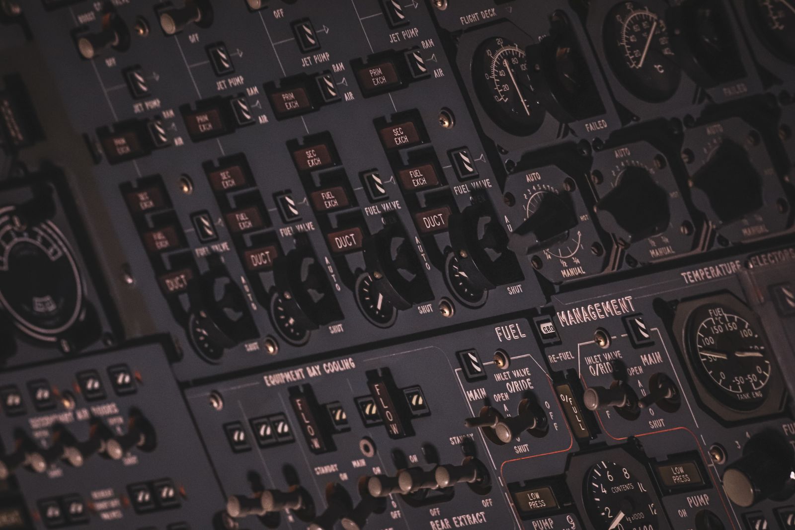 Close-up of an aircraft cockpit's black and gray instrument panel with dials and switches