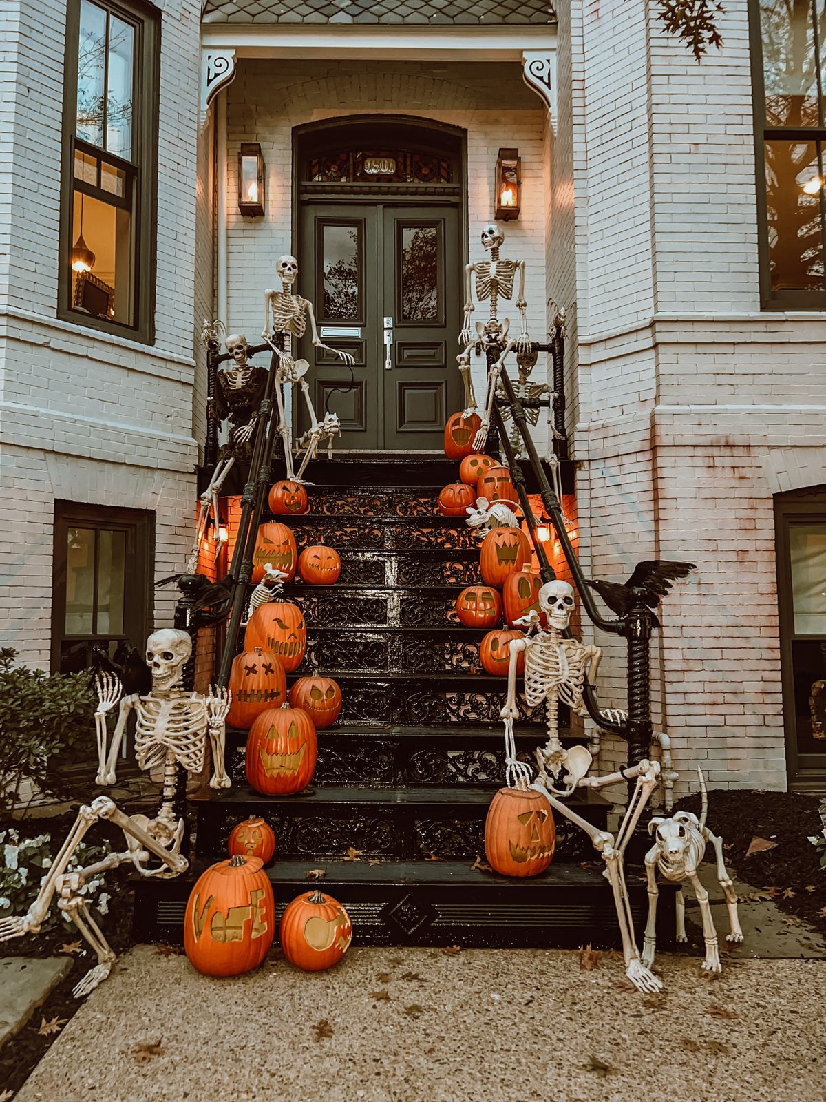 Creepy Halloween scene with skeletons and carved pumpkins on outdoor stairs