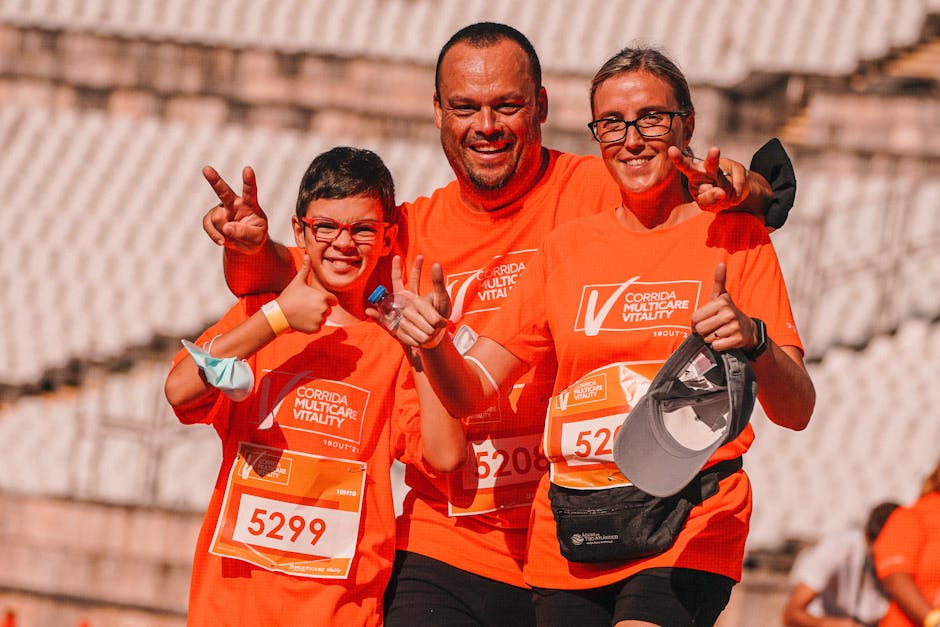 A joyful family shares a moment of victory after finishing a race, wearing matching orange shirts.