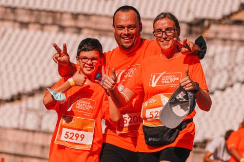 Free A joyful family shares a moment of victory after finishing a race, wearing matching orange shirts. Stock Photo