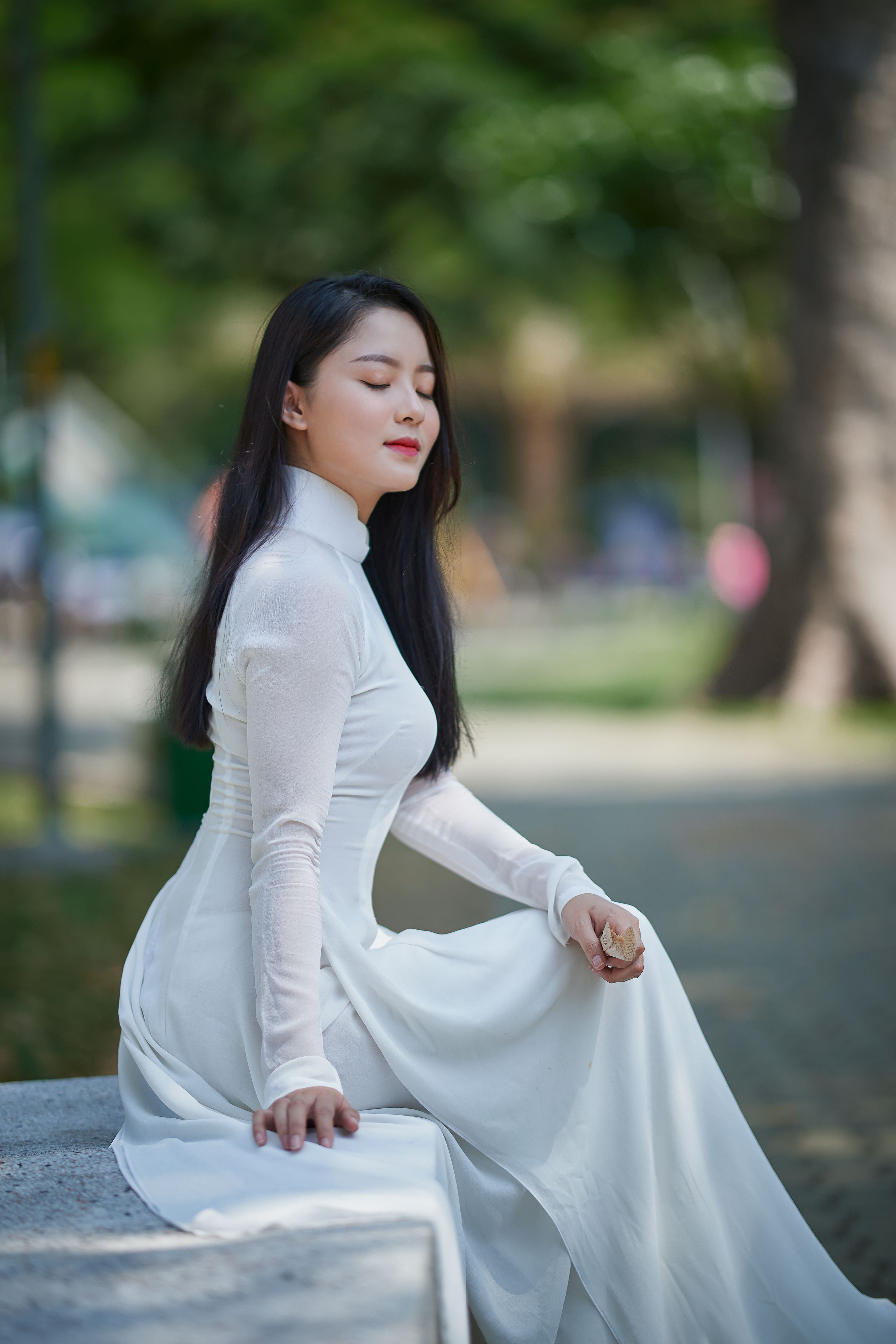 Woman in White Long Sleeve Dress Sitting on Gray Concrete Bench · Free ...
