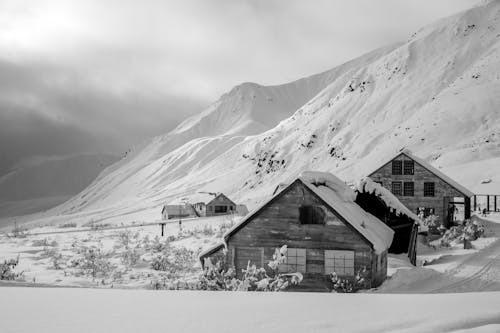 Grayscale Photo of House on Snow Covered Ground