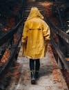 Person in Yellow Raincoat Walking on Footpath