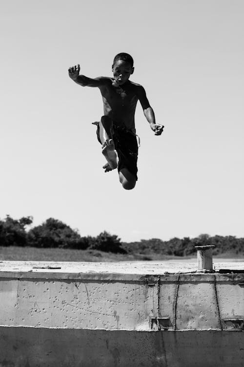 Monochrome Photo of Man Jumping on Mid Air