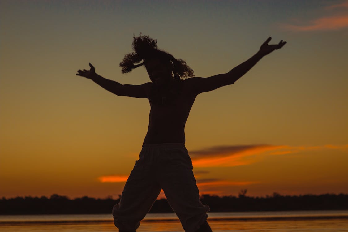 Silhouette of a Man Raising His Hands