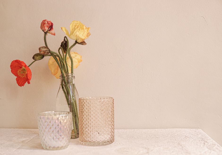 Poppies and ranunculus in a glass vase on a linen table — photo by Elle Hughes on Pexels