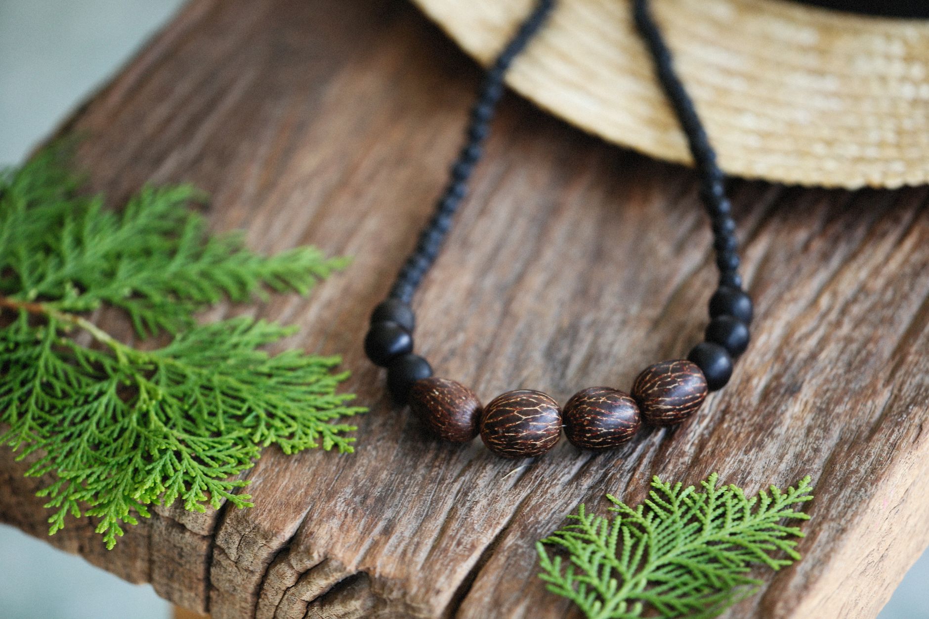 FB廣告素材選擇:圖片還是影片?實用指南 Handmade wooden bead necklace on rustic wooden surface with green leaves, evoking a natural, earthy feel.