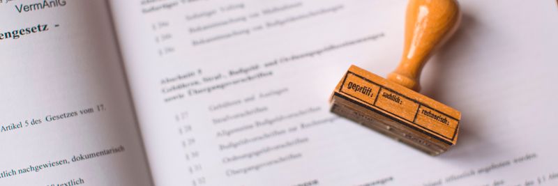 Close-up of a legal document with a wooden stamp placed on top, highlighting verification.