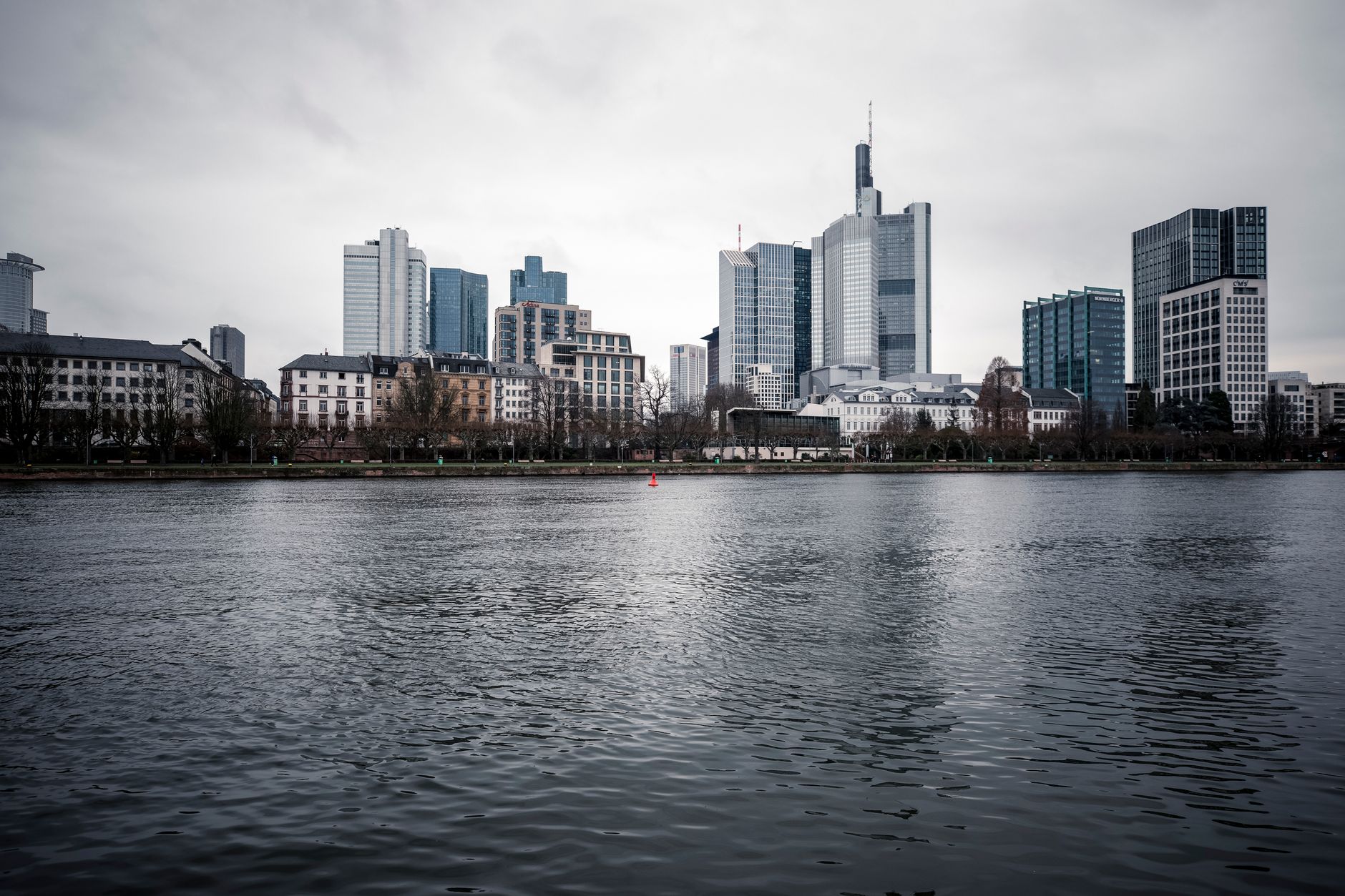View of Frankfurt's skyline under an overcast sky across the river.