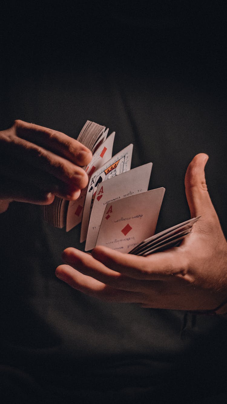 A Person Holding A Deck Of Cards 