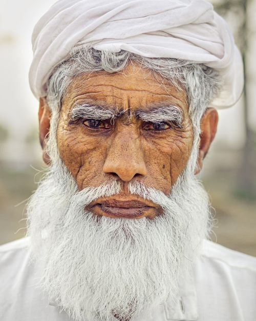 Free Close-up portrait of a senior man with a white beard and turban, displaying a serious expression. Stock Photo