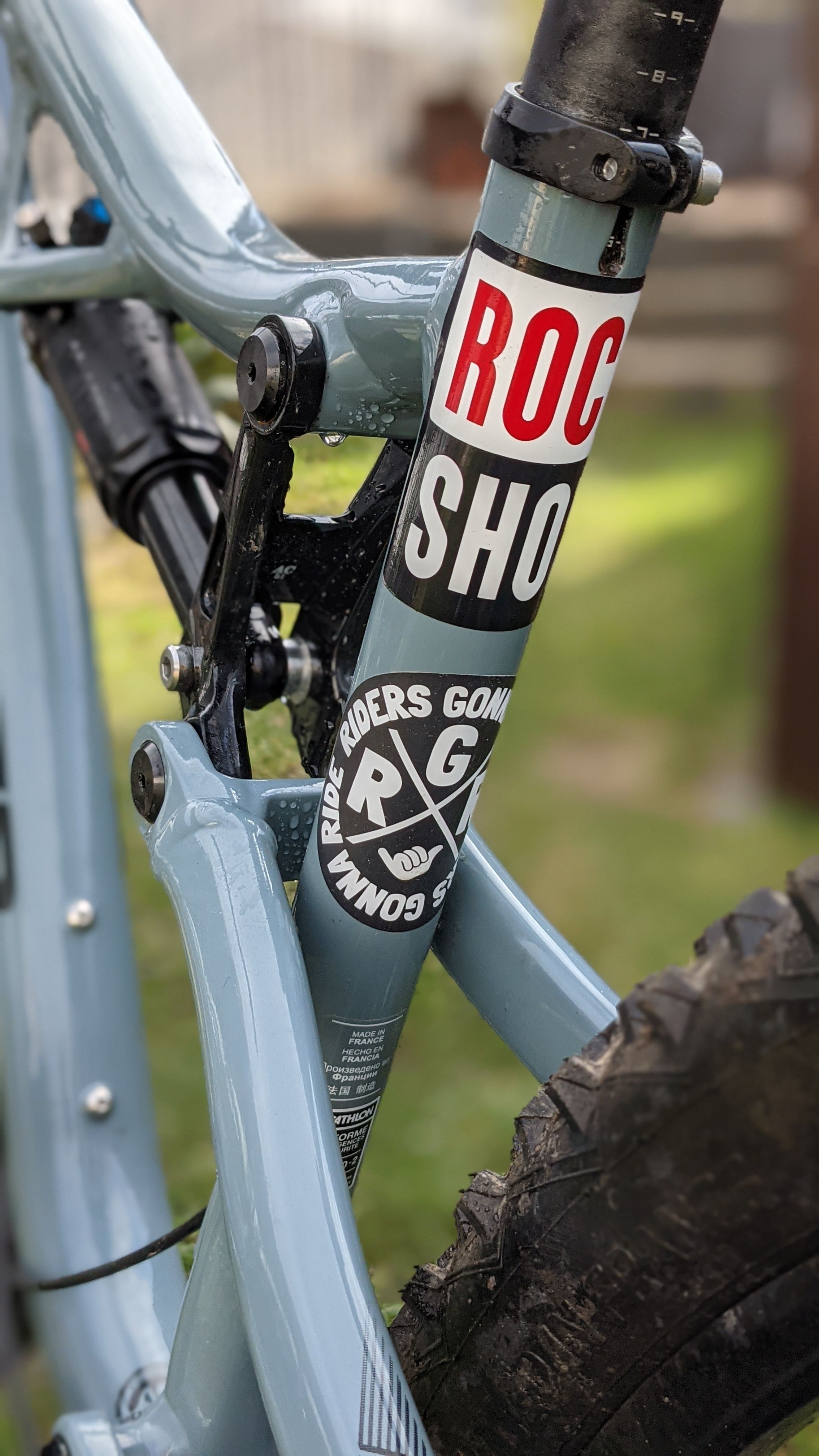 Detailed close-up of a mountain bike frame displaying colorful stickers.