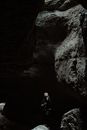 Woman in Black Jacket Standing in Cave