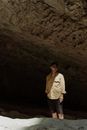 Man in White Dress Shirt and Black Pants Standing Near Brown Rock Formation