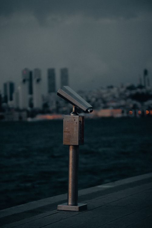 Free Public binoculars facing the Bosphorus in Istanbul at twilight. Dramatic skyline. Stock Photo