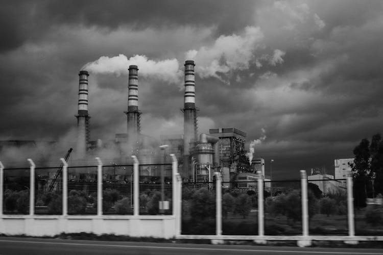 Grayscale Photo Of Smokestacks