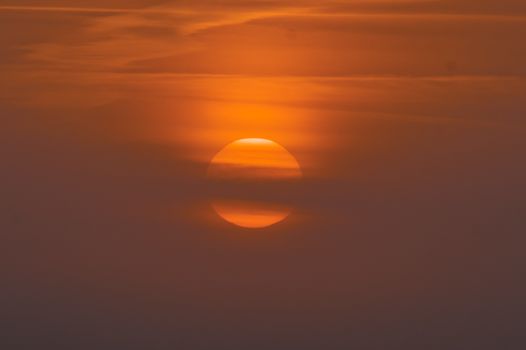 A tranquil sunset with vivid orange hues illuminating the sky, casting a warm glow.