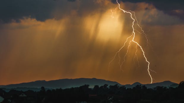 Thunderstorm with dramatic lightning striking over mountains at night, capturing raw energy and nature's power.