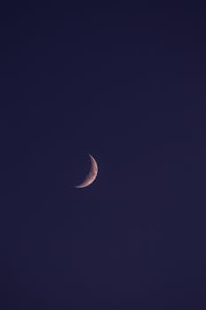 Serene crescent moon against a deep, dark night sky.