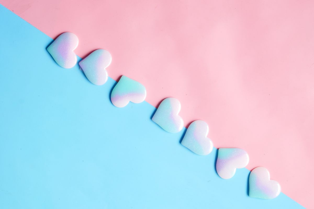 Pastel heart-shaped candies on pink and blue background evoke a sweet and cute aesthetic.