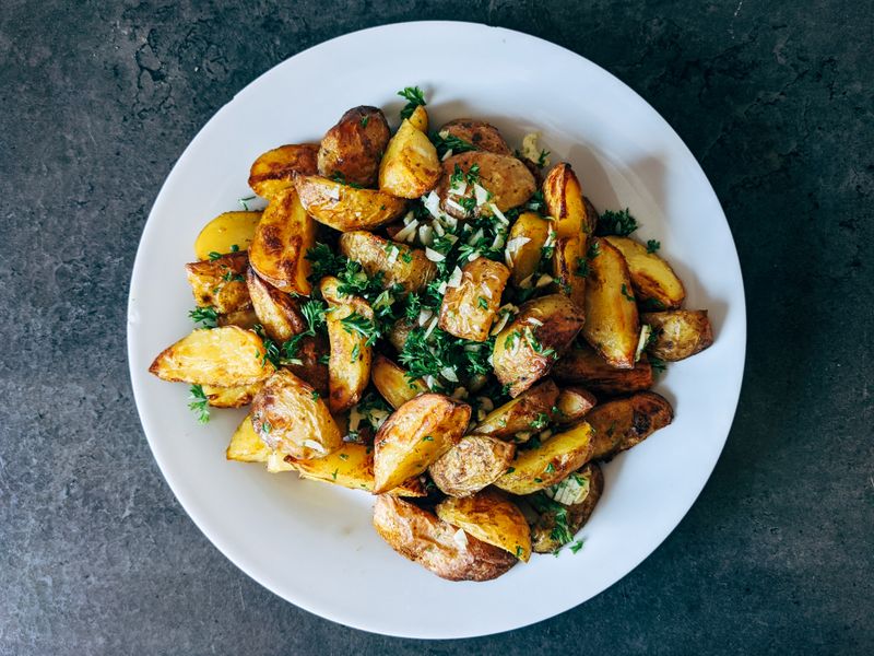 Herb-roasted potato wedges on a white plate — photo by Markus Winkler on Pexels