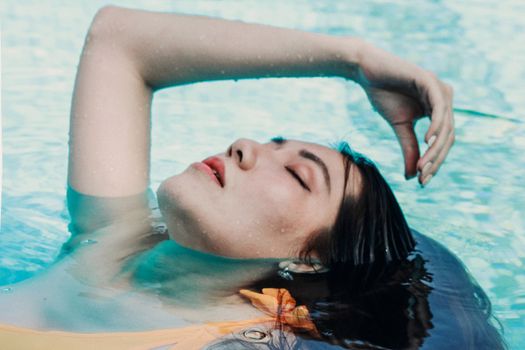 A serene capture of a woman floating with closed eyes in a swimming pool.