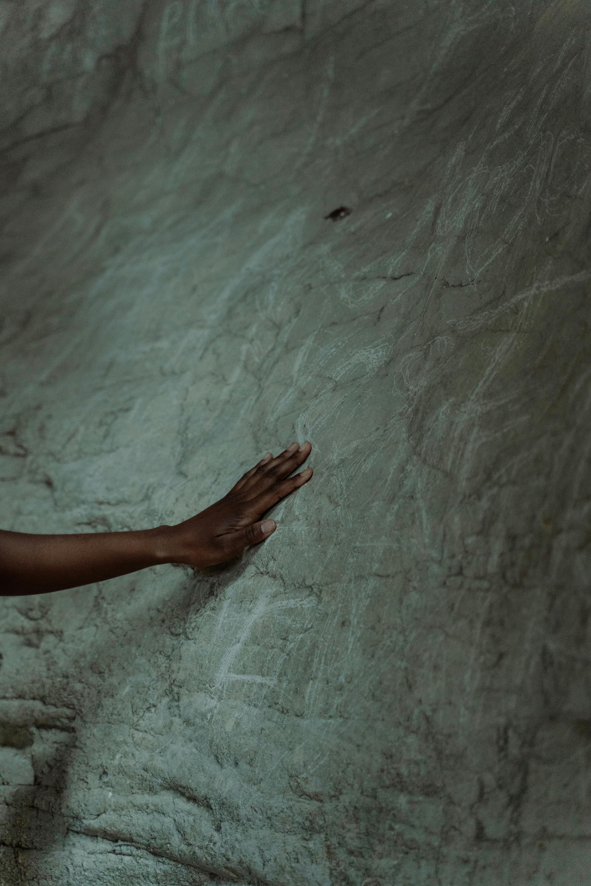 a person touching the cave wal