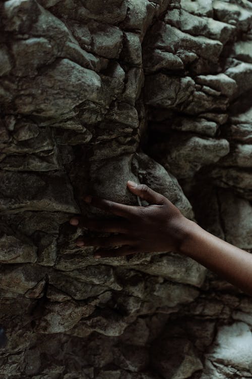 Hand Touching a Rock Surface