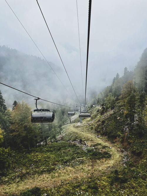 Free A serene cable car ride through a foggy, forested mountain landscape. Stock Photo