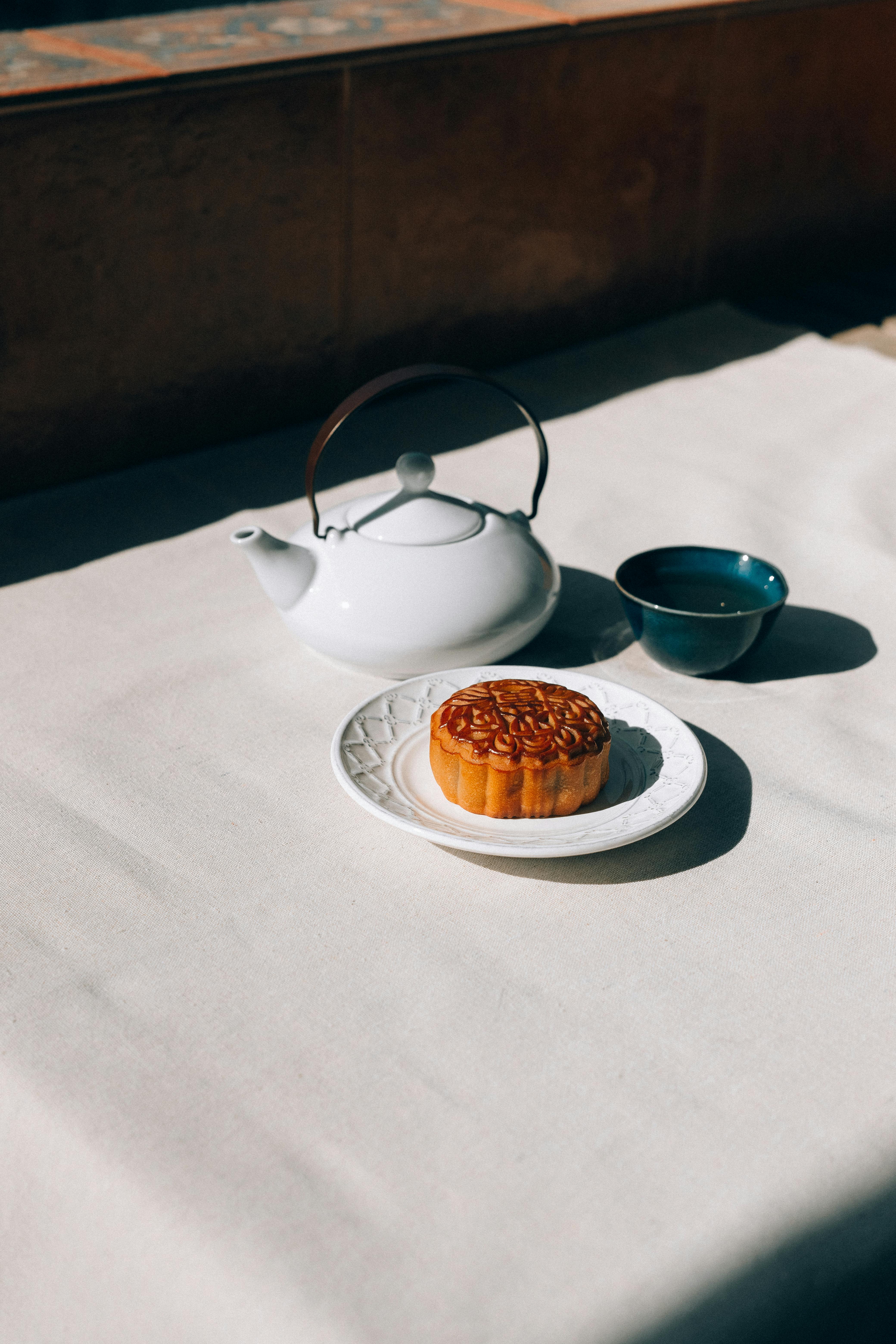 dessert on ceramic saucer beside a teapot