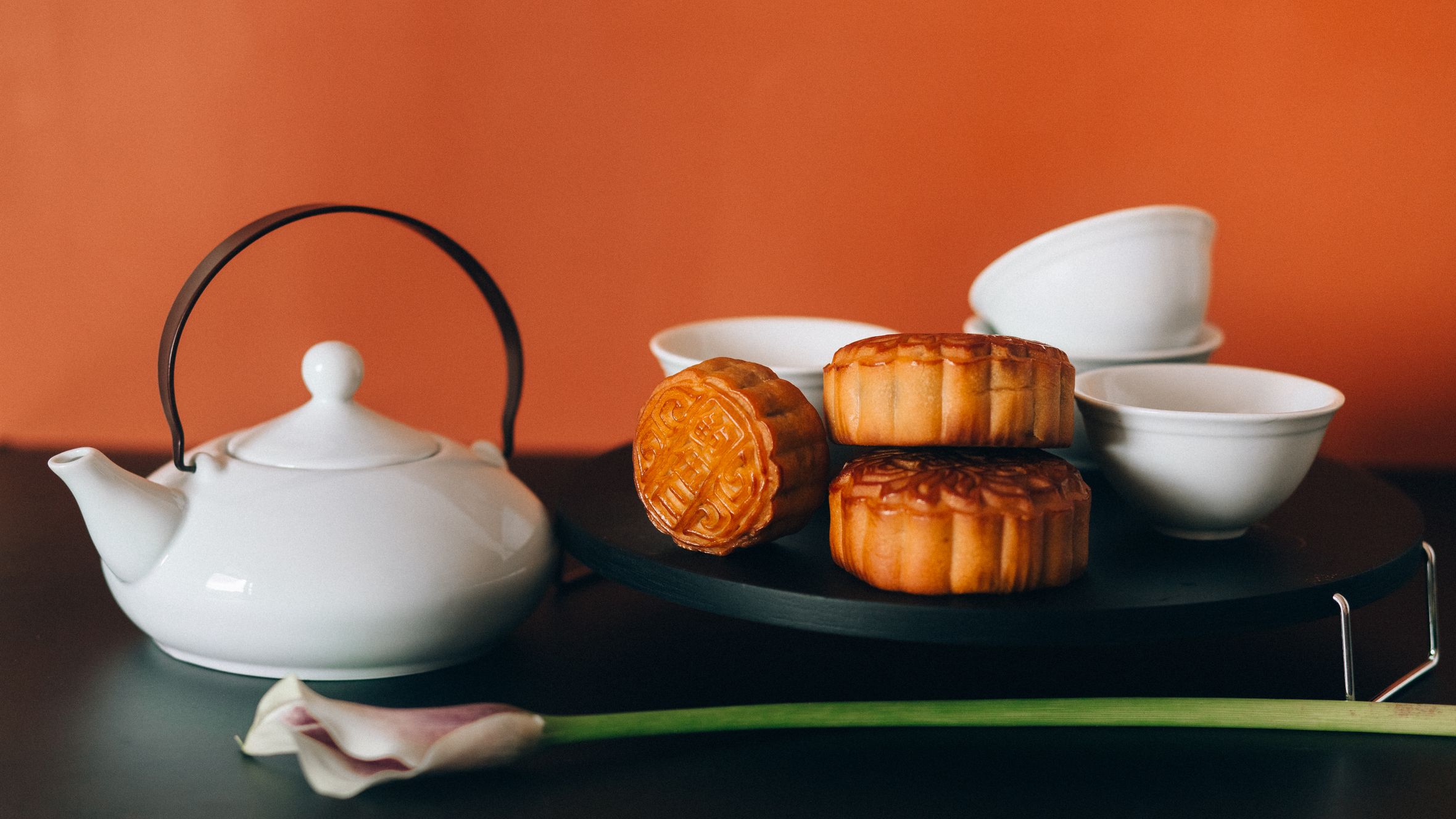 Mooncakes with white teapot and cups, perfect for Mid-Autumn Festival celebrations.