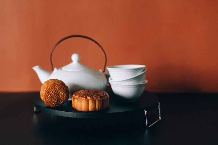 Stacked Teacups And Mooncakes On A Black Tray