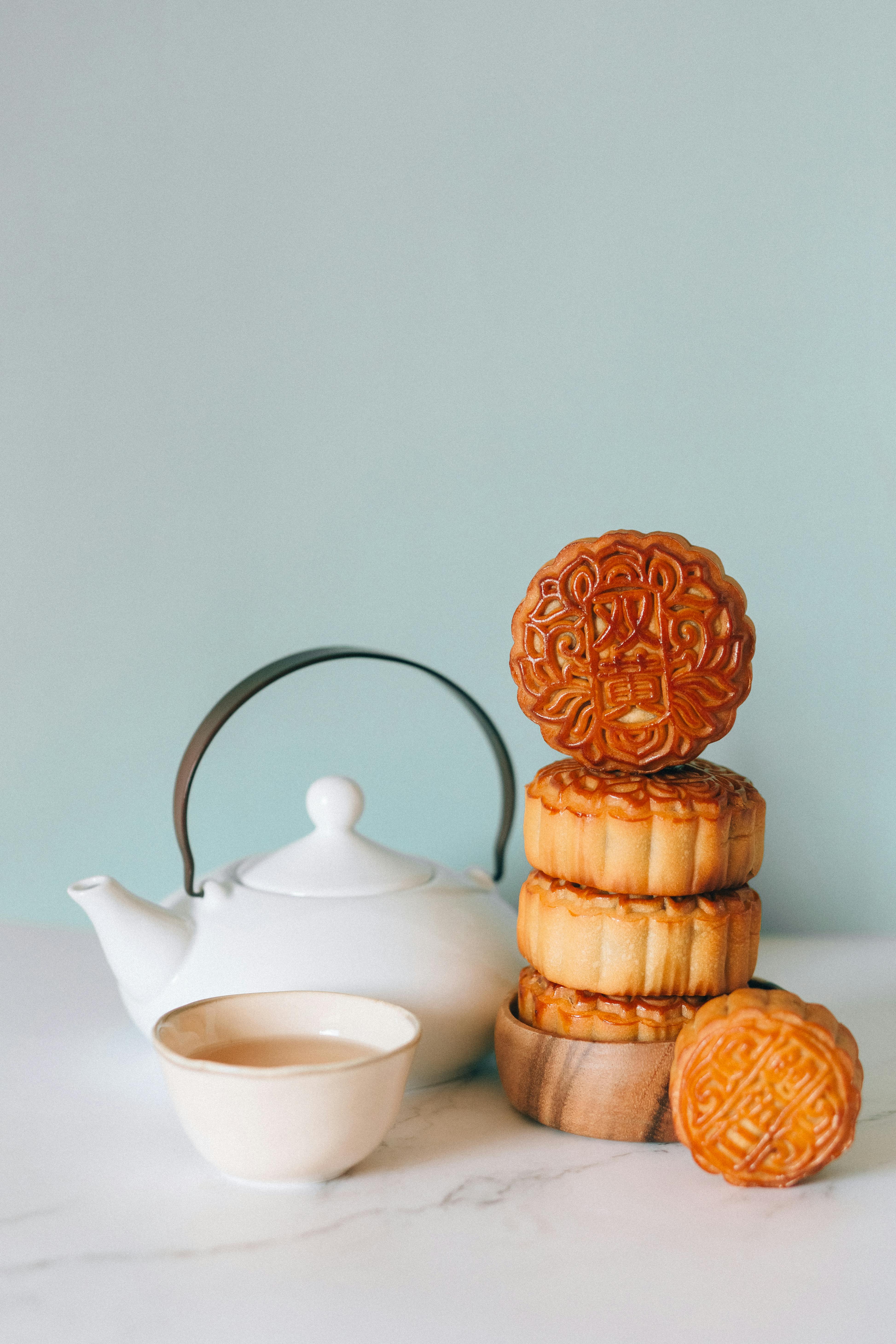 white ceramic teacup on saucer beside brown cookies