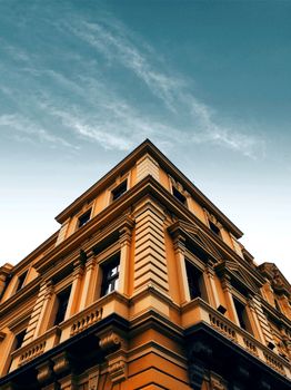 Low angle view of a historic building facade beneath a clear blue sky, showcasing architectural details.