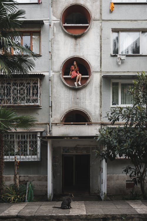 Woman Sitting on Architectural Feature