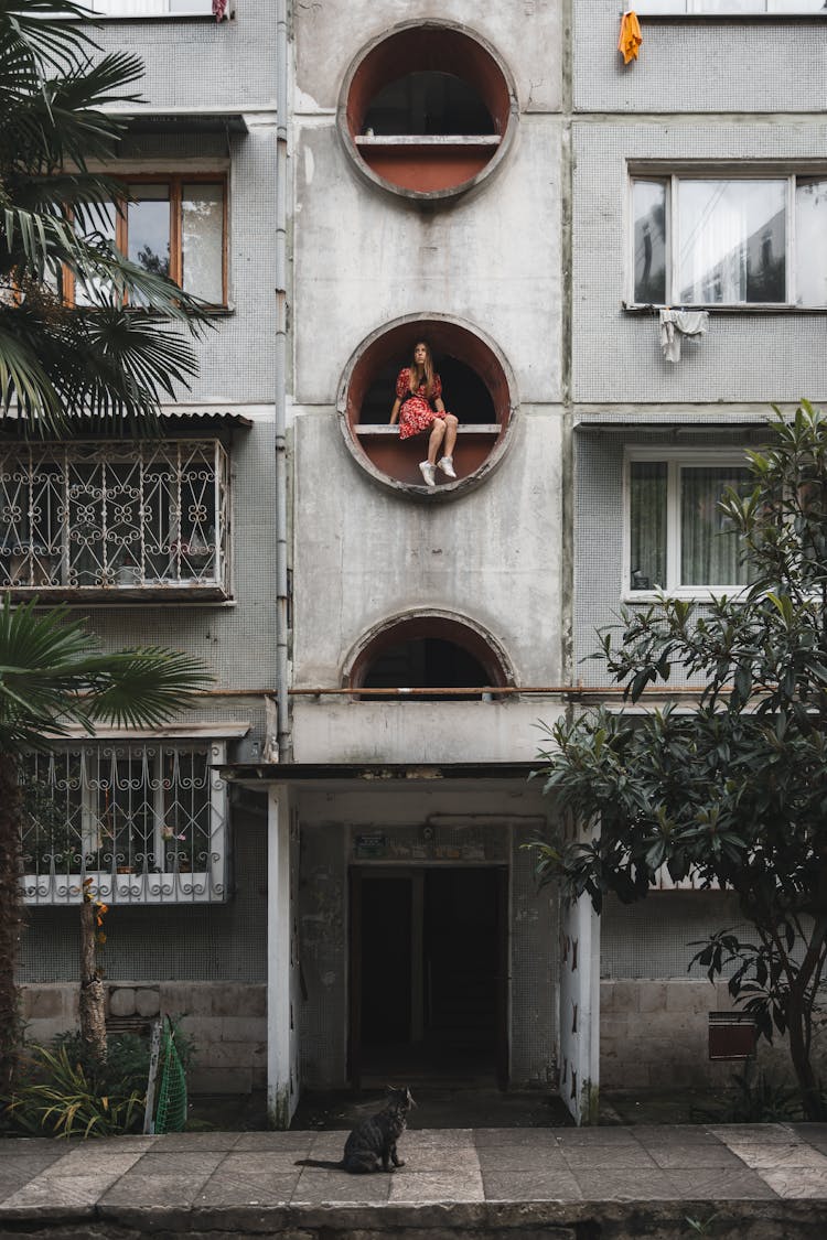 Woman Sitting On Architectural Feature