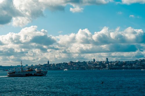 Free A ferry sails in the Bosphorus with Istanbul skyline under a bright blue sky. Stock Photo